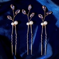 Detalle de tres horquillas doradas con circonitas y perlas sobre seda azul de lujo - Tres Horquillas / Estilo Dorado (HS-J7437G)