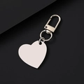 Polished heart-shaped metal keychain with spring snap hook on a black textured surface - Slanted Heart / 30x28.5mm / Silver