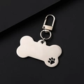 Close-up of bone-shaped stainless steel dog tag with hollow paw print and lobster clasp - Large Bone (Hollow Paw) 34mm Clasp / Silver
