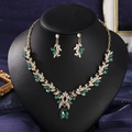 Detailansicht von goldenem Blumenschmuckset mit grünen Kristallen und Diamanten auf Ständer - Grün Stil 6