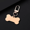 Close-up of a rose gold bone-shaped metal keychain with a secure lobster clasp - Rose Gold Bone Shape Clip
