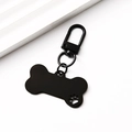 Detail of bone-shaped black metal pet ID tag with a hollow paw print and lobster clasp - Black Hollow Bone Shape Clip