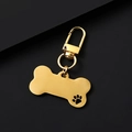 Detailed view of bone-shaped golden metal pet tag with brushed texture and paw cutout - Gold Hollow Bone Shape Clip