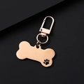 Polished rose gold bone-shaped pet ID tag with a lobster clasp and paw print detail - Rose Gold Hollow Bone Shape Clip