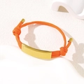 Adjustable bright orange braided rope bracelet with a curved gold plated metal plate - Orange Rope / Gold Metal Plate