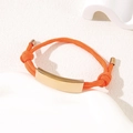 Adjustable orange braided rope bracelet with a plain gold curved metal bar detail - Orange Rope / Rose Gold Metal Plate