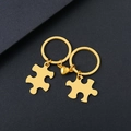 Polished gold stainless steel heart puzzle keychain set for couples on black background - Gold Puzzle Magnet Keychain Pair