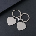 Macro shot of polished magnetic heart-shaped stainless steel keychains for couples - Heart Silver Pair