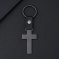 Minimalist black metal cross keychain with black leather strap on a textured grey background - Black Cross