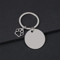 Macro detail of blank stainless steel round tag with hollow dog paw charm on black surface - 30mm Round Silver