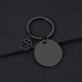 Close-up of black metal keychain with a blank round tag and hollow paw print charm - 30mm Round Black