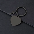 Detail view of matte black cross and heart metal keychains on textured surface - Heart Style / Black