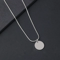 Makroaufnahme der silbernen Schlangenkette und des glatten runden Edelstahl-Anhängers - Schlangenknochen-Halskette / 15mm Innenloch Rund / Silber