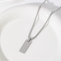 Detail of a minimalist silver rectangular pendant with a sturdy box chain on white ceramic - 25X10mm Rectangle With Box Chain / Silver