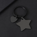 Détail des breloques cœur et étoile en acier inoxydable noir mat sur l'anneau porte-clés - Style Noir