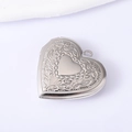 Close-up of engraved floral patterns on silver stainless steel heart locket pendant - Silver