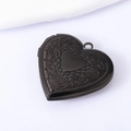 Detail of vintage gunmetal heart locket with floral engraving and hinge structure - Black