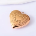 Golden heart locket necklace with floral relief and polished center on white background - Rose Gold