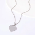 Polished silver heart-shaped stainless steel pendant on a fine link chain macro view - Heart Necklace (Silver)