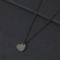 Dettaglio macro della collana con ciondolo a cuore nero opaco e catena sottile coordinata - 15*14mm / Nero