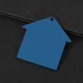 Macro-opname van een blauwe huisvormige metalen label met gepolijste afwerking en een boorgat - Blauw