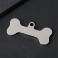 Macro shot of bone-shaped pet ID tag in brushed stainless steel with engraving detail - Bone Style / 34.8x16.4mm / Brushed Silver