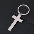Detailed view of polished stainless steel cross pendant keychain on black textured card - Silver