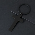 Close-up of a matte black stainless steel cross keychain on a textured dark background - Black