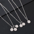 Detail van spiegelgepolijste roestvrijstalen ronde schijfhangers aan fijne kruiskettingen - Zilver (1 Schijf)