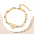 Elegant gold Cuban chain bracelet featuring a polished heart pendant on a white platform - Heart Tag (Gold)