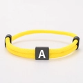 Adjustable yellow woven Milan rope bracelet with a black square block featuring letter A - Letter A / Yellow