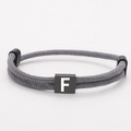 Adjustable grey woven rope bracelet featuring a black square block with white letter F - Letter F (SLF006) / Gray