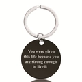 Macro detail of black stainless steel round keychain with engraved motivational quote - Life Strength Motivation Style (Y00006)