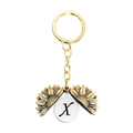 Détail du porte-clés tournesol avec la lettre X gravée à l'intérieur du pendentif doré - Style Lettre X (T00048) / Or