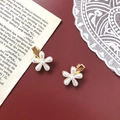 Detalle de dos pinzas de pelo de flor dorada con perlas sobre fondo rojo oscuro - Estilo de 1 Flor