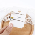 Detail von süßen Perlen-Katzenpfoten und gemalten Kätzchen-Haarclips auf Karte - Zweifarbig-ohrige Katze