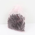 Detailed view of black elastic hair ties stored in a pink organza drawstring bag - Organza Bag - All Black
