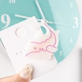 Detail of shark-shaped white acetate hair clip with pink edges on a card - Whale