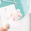 Detail of cream acetate bear hair clip with pink stitching on branded display card - Panda
