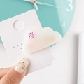 Detailed view of a white cloud hair clip with pink sun accent on a display card - Cloud