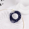 Primer plano de gomas de pelo azul oscuro con clip en forma de oso en una bandeja de cristal - Azul marino