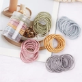 Macro shot of colorful high-elasticity seamless hair bands in a transparent jar - Thin Style Spring Colors