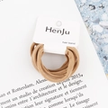 Close-up of elastic khaki hair bands displayed on a branded card for easy storage - Ginger Yellow