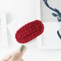 Detail of red hand-knitted yarn BB hair clip showing the thick wool texture and stitching - Burgundy