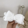 Macro view of white coral fleece headband with soft texture and bowknot detail - White