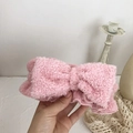 Close-up of soft pink plush bow headband for face washing and skincare routines - Pink