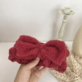Detailed view of a soft burgundy fleece headband with a large bow for face washing - Red