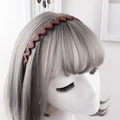 Close-up of matte brown wavy headband with anti-slip teeth on a mannequin model - Brown