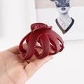 Detail of a large burgundy matte hair claw clip held by hand for size reference - Burgundy