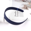 Dettaglio del cerchietto blu navy opaco con denti antiscivolo su una rivista estetica - Blu navy
